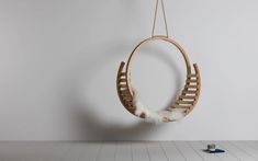 a wooden hammock hanging from a string