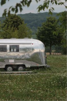 an airstream is parked in the middle of a field