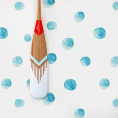 a wooden toothbrush sitting on top of a blue and white polka dot wallpaper