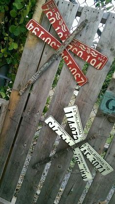 a wooden fence with several street signs attached to it