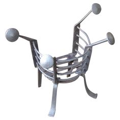 a metal chair with two balls on it's legs and one arm extended to the ground