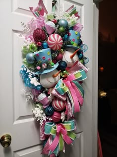 a christmas wreath hanging on the front door with candy and candies around it's edges