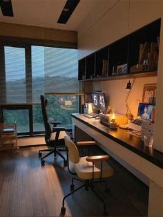 an office with a desk and chair in front of a large window overlooking the mountains