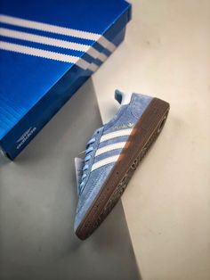 a blue adidas sneaker sitting on top of a table next to a box