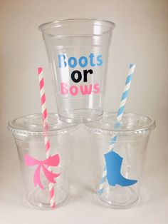 three plastic cups with straws and one has a princess crown on the side, two have blue and pink striped straws