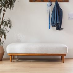 a white bench sitting next to a potted plant