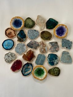 a group of different colored rocks sitting on top of a white surface