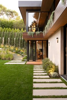 a modern house with grass and stone walkways