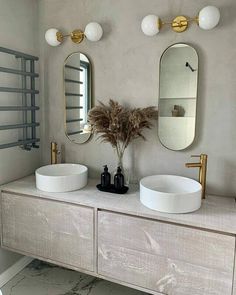 two white sinks sitting next to each other on top of a wooden cabinet in a bathroom