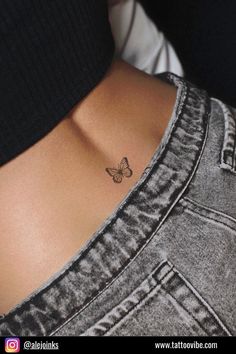 a small butterfly tattoo on the back of a woman's lower back ribcage