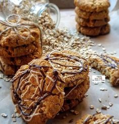 cookies with chocolate drizzled on top and oats scattered around