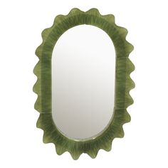 a green oval mirror sitting on top of a white wall