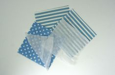 four pieces of blue and white polka dot fabric on a table top with one piece folded in half