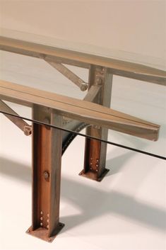 a wooden bench sitting under a glass table top on a white surface with metal legs