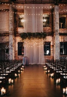 an indoor venue with rows of chairs and candles