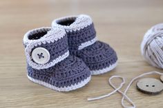 a pair of crocheted baby shoes sitting on top of a wooden floor