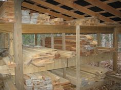 logs stacked on top of each other in a wooden structure with wood slats around them