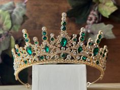 Beautiful, sparkles, good quality Tiara with Green stones, with Crystal Rhinestone set on gold Tiara. Perfect for Prom, Birthday, Sweet 16, Wedding Anniversary, or for any other special occasion. Or just to be THE QUEEN. THE COLORS ON THE TIARA: Gold tiara frame, Green and Crystal clear Rhinestone THE SIZE 2.75 inche tall on the front. 1.25 inches tall on the sides. GIFT BOX IT'S NOT INCLUDED! This item it will send on STANDARD FIRST CLASS MAIL (2 to 5 business days). in USA If you need sooner, Green And Gold Tiara, 16 Wedding Anniversary, Emerald Green Tiara, Green Tiara, Green Birthday Cakes, Birthday Sweet 16, Prom Tiaras, Tiara Gold, Prom Birthday