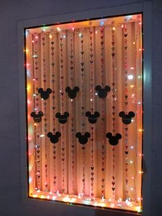 a lighted window with mickey mouse heads on it