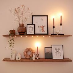 two shelves with pictures and candles on them