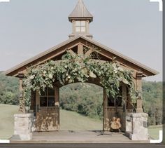 an outdoor gazebo with flowers and greenery on it