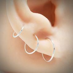 These minimalist and modern cartilage hoops are made from 20 gauge wire and are hand forged by me. These are ear hugging hoops in your lobe piercings, as shown in the photo. This listing is for a single endless hoop in 20 gauge wire handcrafted tiny size nose ring/hoop earring. Classic and simple design, great for everyday, lightweight and very comfortable. They would also work as for all your piercings, 2nd and 3rd piercings, helix, nose and tragus. These delicate and lightweight hoops are appr Minimalist Internally Threaded Hoop Piercings, Minimalist Adjustable Hoop Piercings, Adjustable Hypoallergenic Minimalist Septum Ring, Elegant Small Hoop Cartilage Earrings With Ear Wire, Minimalist Hypoallergenic Small Hoop Cartilage Earrings, Adjustable Hypoallergenic Minimalist Piercings, Minimalist Adjustable Hypoallergenic Piercings, Minimalist Internally Threaded Huggie Cartilage Earrings, Internally Threaded Minimalist Septum Ring