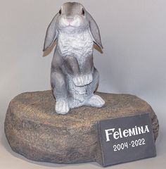 a statue of a rabbit sitting on top of a rock