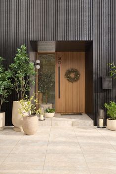 the front door is decorated with potted plants