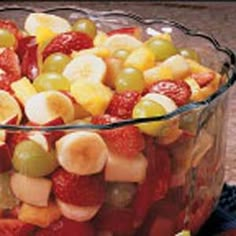 a glass bowl filled with fruit salad on top of a table