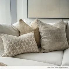 a white couch with several pillows on it