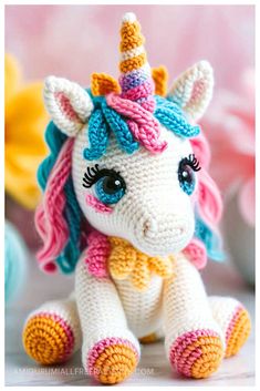 a crocheted stuffed unicorn sitting on top of a table