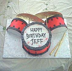 a birthday cake with drums and sticks for jeff's drummers on the side