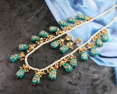 This gorgeous OOAK necklace features so many beautiful tanjore paint gemstones tumbles, kundans & pearls!  This is a stunning handmade necklace perfect for high end Jewelry Collector, a keeper in Traditional Vintage Indian/Pakistani Bridal jewelry and a Luxury Gift for your Daughter, Sister or Wife on Wedding or Anniversary. Perfect for any type of occasions, weddings And celebrations and a beautiful & memorable gift for weddings and special occasions. Description  Item Code:- L Teal Blue Gemstone Tumble Tanjore Paint Necklace Necklace Measures: 11" Long excluding adjustable dori/cord Earring Measures: 55x14mm approx Material: Brass, Pearl & Teal Blue Gemstones Quantity: One Necklace Set Please see more different designs here:- https://www.etsy.com/in-en/shop/LUCKYJEWELSART?ref=seller-plat Traditional Beads With Stones As Gift, Traditional Stone Beads As Gift, Traditional Stone Beads For Gifts, Gold Beads With Stone Work For Gifts, Bridal Necklace With Stones For Festival Gifts, Turquoise Kundan Necklace Temple Jewelry Gift, Turquoise Jewelry With Stone Work For Gift, Traditional Beads With Stones For Jewelry Making, Turquoise Jewelry For Diwali Gift