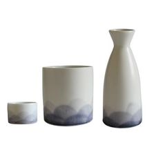 three white vases and two cups on a white background