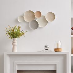 a white fireplace with some vases on top of it