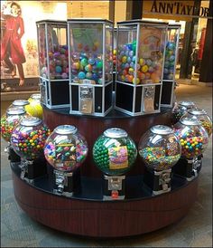 there are many different types of gumballs in the display case at the storefront