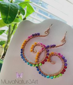 a pair of colorful beaded earrings sitting on top of a white mannequin