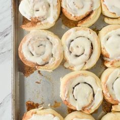 a baking pan filled with cinnamon rolls covered in icing