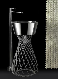 a metal vase sitting on top of a table next to a wall covered in sound panels