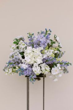 a vase filled with lots of white and blue flowers