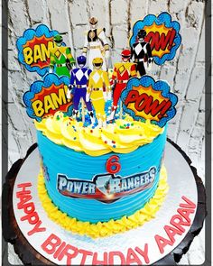 a birthday cake decorated with cartoon characters and the words power rangers on it's frosting