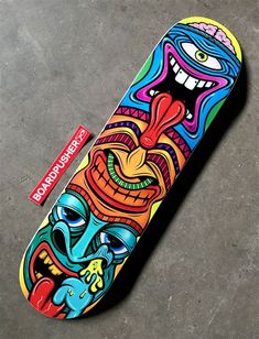 a skateboard with an artistic design on the top and bottom part is laying on concrete