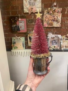 a person holding a coffee cup with a christmas tree on it