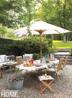 an outdoor dining area with chairs, tables and umbrellas in the middle of it