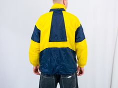 "UNCLE ED PRESENTS - vintage 90's yellow-blue windbreaker - the hood hidden in the collar - 2 outside pockets - lined - material: shell - 100% nylon; lining - 100% cotton. CONDITION (1-10 ❶❷❸❹❺❻❼❽❾ Great condition. SIZE/MEASUREMENTS size from label: M; women 40-42, men 48-50 best fits men: M/L chest: 51 inches (130 cm) length: 30 inches (76 cm) sleeve length from armpit: 18,5 inches (47 cm) The model is 6'1\" (186 cm), measures 41-35-39 (104-88-100 cm) and wears size L" Retro Yellow Windbreaker For Streetwear, Yellow Retro Windbreaker For Streetwear, Hooded Yellow Windbreaker For Streetwear, Yellow Hooded Windbreaker For Streetwear, Yellow Sporty Windbreaker For Outdoor Activities, 90s Style Yellow Windbreaker For Streetwear, Retro Yellow Hooded Windbreaker, Yellow Hooded Sporty Windbreaker, Yellow Sporty Windbreaker For Streetwear