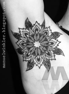 a black and white photo of a woman's stomach with a flower tattoo on it