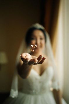 a woman in a wedding dress is holding out her hand with the ring on it