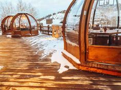 an outdoor hot tub in the middle of a snow covered field with wooden walkways