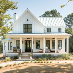 a large white house with lots of windows on the front and side of it's porch