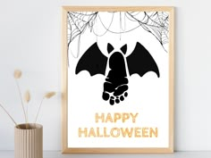 a black and white poster with a bat hanging from it's side next to a vase